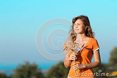 Young beautiful girl in the field with ears in the hand Stock Photo