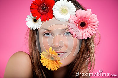 Young beautiful girl with flower in her mouth and her hair. Studio portrait with bright colours. Beauty and youth concept Stock Photo