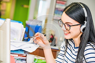 Young beautiful girl with glasses and headphones in office Stock Photo