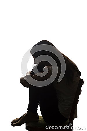 Young beautiful girl in grief hugged her knees - silhouette Stock Photo