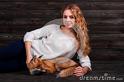 A young beautiful girl holding a wild fox animal that was traumatized by a man and rescued by her and now lives as before Stock Photo