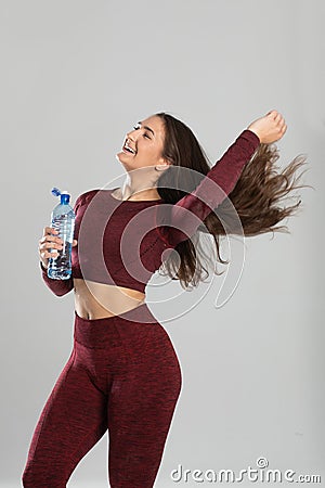 Young beautiful girl with mineral water isolated on white , portrait of beautiful young fit woman drinking water during traning Stock Photo