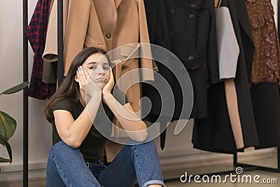 A young girl tired of shopping, sitting sad. Stock Photo