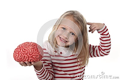 Young beautiful girl 6 to 8 years old playing with rubber brain having fun learning science concept Stock Photo