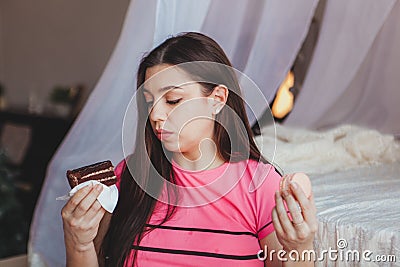 Young beautiful girl and tough choice between two cakes Stock Photo