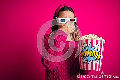 Young beautiful girl watching movie using 3d glasses eating box with popcorns smelling something stinky and disgusting, Stock Photo