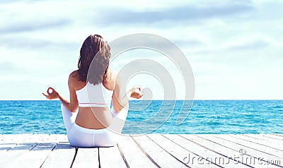 Young and beautiful girl in white sportswear doing yoga on a woo Stock Photo