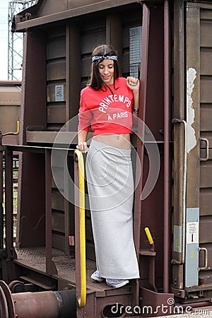 Young beautiful happy teenager girl posing at train station. Stock Photo