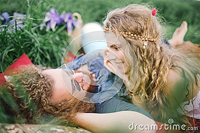 Young beautiful hippie couple lying on grass having fun Stock Photo