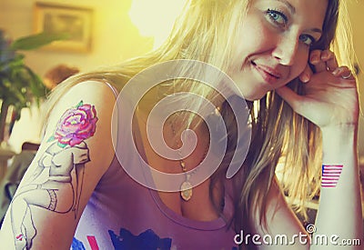 Young beautiful hipster woman with blonde hair and tattoo hands in cafe Stock Photo