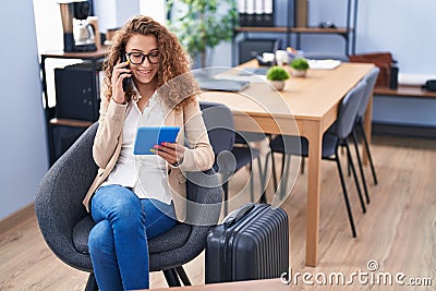 Young beautiful hispanic woman business worker waiting for travel talking on smartphone at office Stock Photo