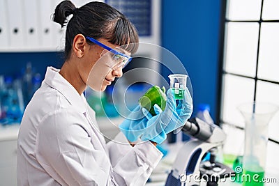 Young beautiful hispanic woman scientist holding pepper measuring liquid at laboratory Stock Photo