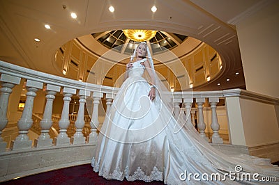 Young beautiful luxurious woman in wedding dress posing in luxurious interior. Bride with huge wedding dress in majestic manor Stock Photo