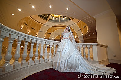 Young beautiful luxurious woman in wedding dress posing in luxurious interior. Bride with huge wedding dress in majestic manor Stock Photo