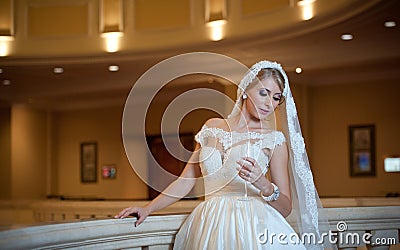 Young beautiful luxurious woman in wedding dress posing in luxurious interior. Bride with huge wedding dress in majestic manor Stock Photo