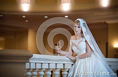 Young beautiful luxurious woman in wedding dress posing in luxurious interior. Bride with huge wedding dress in majestic manor Stock Photo