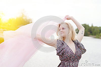 Young beautiful moody blonde female waving silk Stock Photo