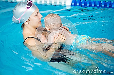 Young beautiful mother visit a swimming pool with her little son Stock Photo