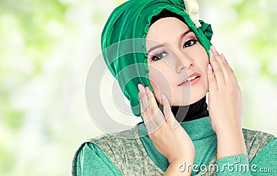 Young beautiful muslim woman with green costume wearing hijab Stock Photo