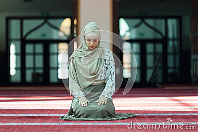 Young beautiful Muslim Woman Praying In Mosque Stock Photo