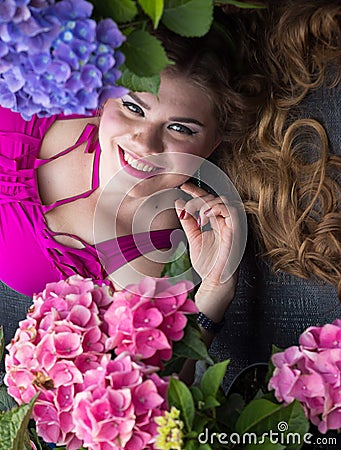 Young beautiful plus size model lying in flowers, xxl woman Stock Photo