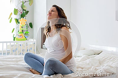 Young beautiful pregnant woman, in pain with labor contraction Stock Photo