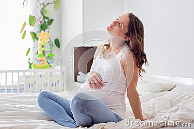 Young beautiful pregnant woman, in pain with labor contraction Stock Photo