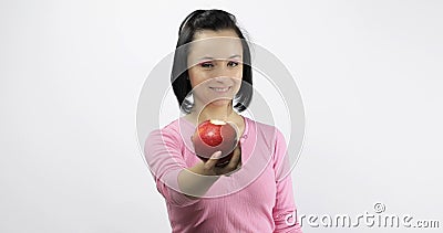 Young beautiful with red apple offer bite to viewer. Healthy nutrition Stock Photo