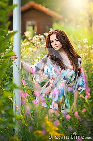 Young beautiful red hair woman in multicolored blouse in a sunny day. Portrait of attractive long hair female in nature Stock Photo