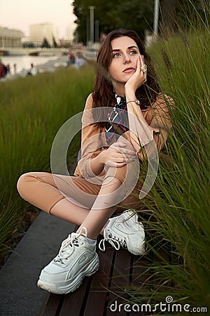 Young beautiful red haired gen z girl wearing slim fitted women beige khaki coverall overall denim jumpsuit or flight Stock Photo