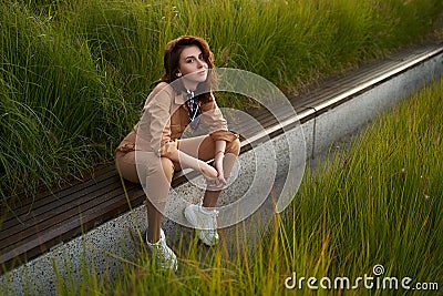 Young beautiful red haired gen z girl wearing slim fitted women beige khaki coverall overall denim jumpsuit or flight Stock Photo