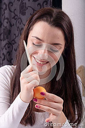 Young beautiful sexy german woman with dark hair paints a Easter egg according to Sorbian tradition with a needle head and melted Stock Photo