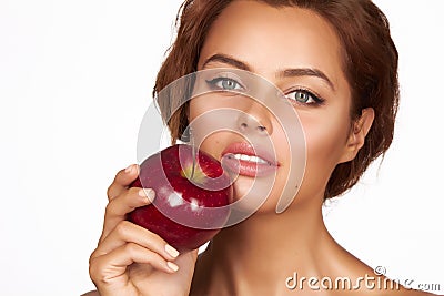 Young beautiful girl with dark curly hair, bare shoulders and neck, holding big red apple to enjoy the taste and are dieting, Stock Photo