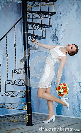 Young beautiful woman with flowers and a spiral staircase Stock Photo