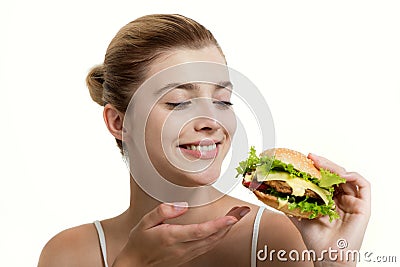 Young beautiful smilling girl holds a burger in hand Stock Photo