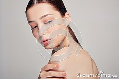 Young beautiful sophisticated girl with blue eyes and full lips holds a hand on his shoulder Stock Photo