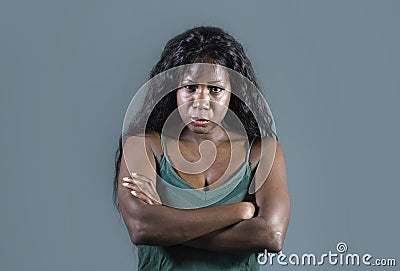 Young beautiful and stressed black African American woman feeling upset and angry looking serious and posing with folded ar Stock Photo