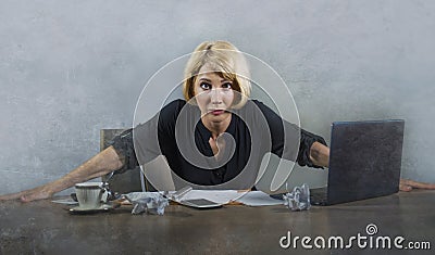 Young beautiful stressed and upset blonde woman working with laptop computer feeling tired overwhelmed by paperwork looking angry Stock Photo