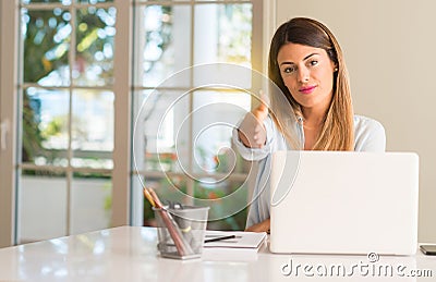 Young beautiful student woman with laptop at table, at home Stock Photo