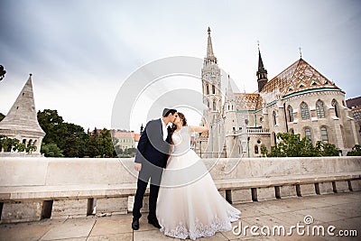 Young beautiful stylish pair of newlyweds kissing by the Fisherman`s Bastion in Budapest, Hungary Stock Photo