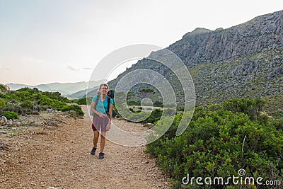 Young, beautiful, teenage woman with backpack hiking in mountains Editorial Stock Photo