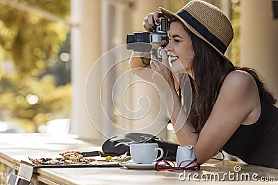 Young beautiful traveler happily taking photos with camera at ca Stock Photo