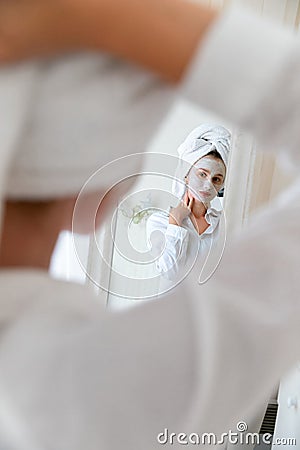 Young beautiful woman apply face mask in bedroom Stock Photo