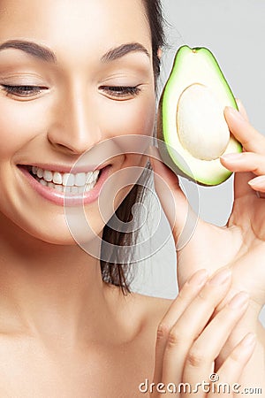 Young beautiful woman with avocado closeup Stock Photo