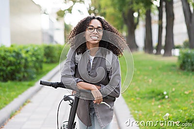 Young beautiful woman with bicycle in city, Cheerful student girl with bike smiling outdoor Stock Photo