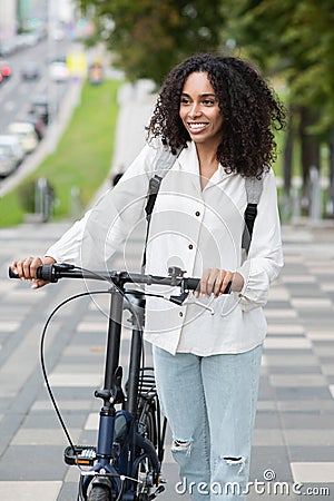 Young beautiful woman with bicycle in a city, Smiling student girl with bike smiling outdoor Stock Photo