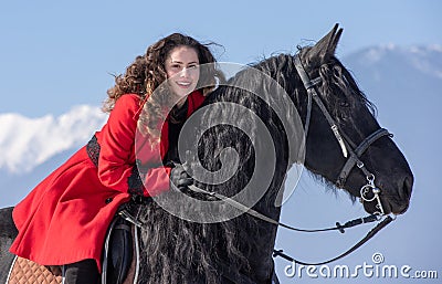 Young beautiful woman on black horse in riding in Transylvania mountains Editorial Stock Photo