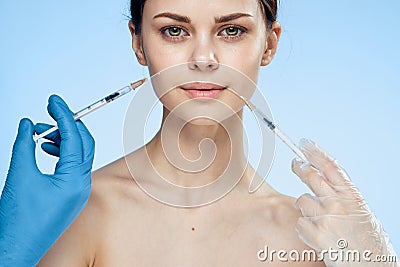 Young beautiful woman on a blue background injects botox, plastic surgery Stock Photo