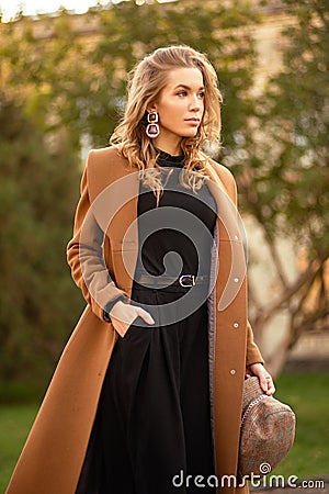 Young beautiful woman in coat posing on city street Stock Photo