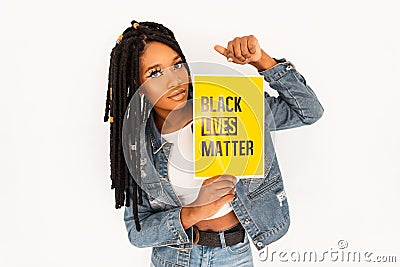Young beautiful woman with dreadlocks in blue jeans clothes protests and holds a yellow poster Black Lives Matter. Editorial Stock Photo